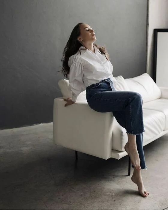 a woman sitting on top of a white couch