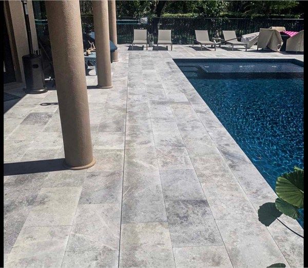 an empty pool surrounded by columns and chairs