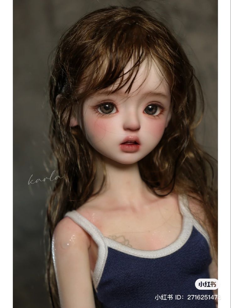 a close up of a doll with long brown hair and blue eyes, wearing a tank top