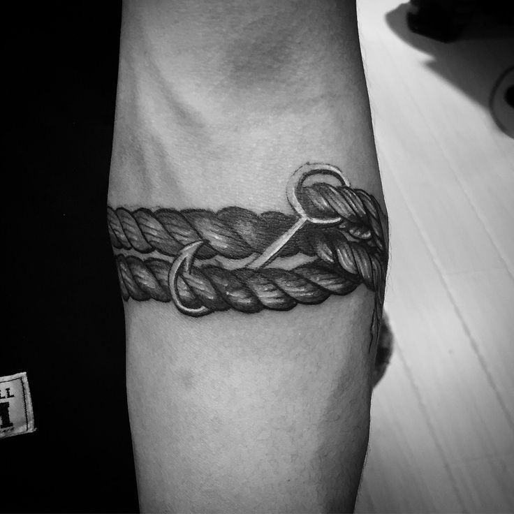 a black and white photo of a man's arm with a tattoo on it