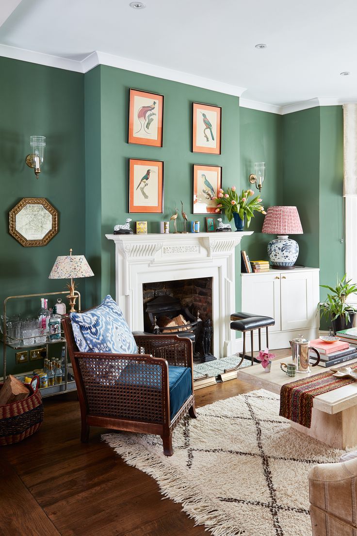 a living room filled with furniture and a fire place in front of a green wall