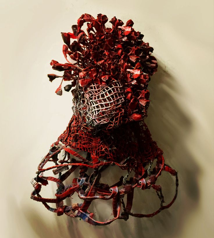 a piece of art that looks like it has been made out of wire and red yarn