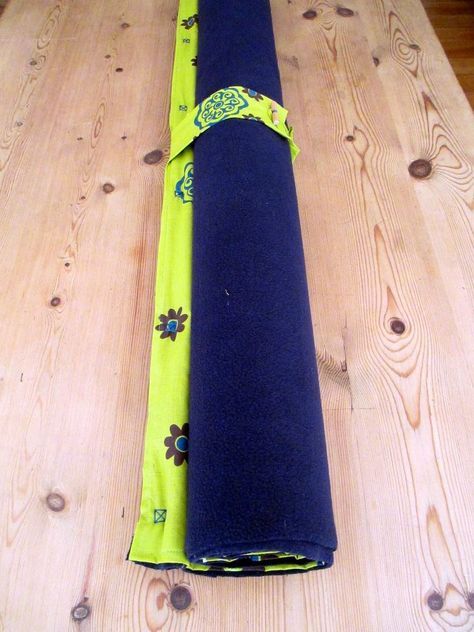 two rolled up yoga mats sitting on top of a wooden table