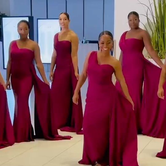 a group of women in red dresses standing next to each other