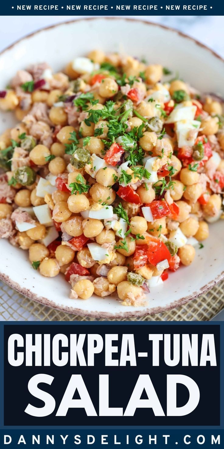 chickpea - tuna salad with tomatoes, onions and parsley in a white bowl