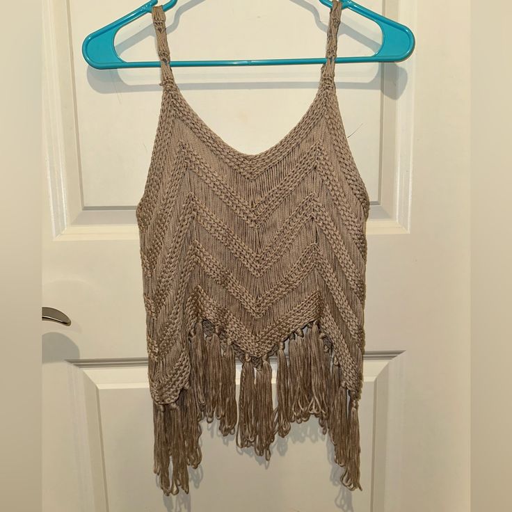 a crocheted top hanging on a door hanger