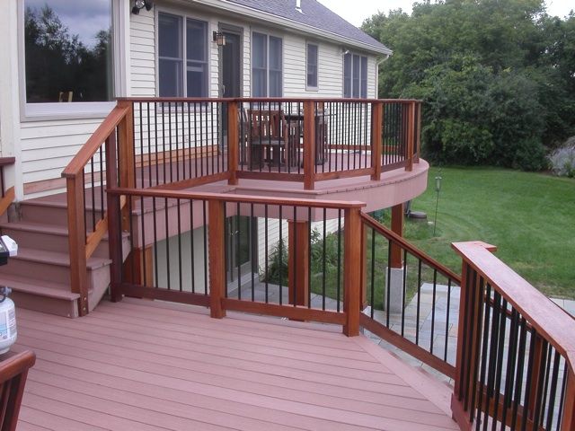 a wooden deck with railings next to a house