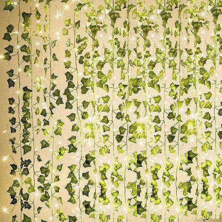 green ivy leaves hanging from the side of a curtain with lights on it and some white stars