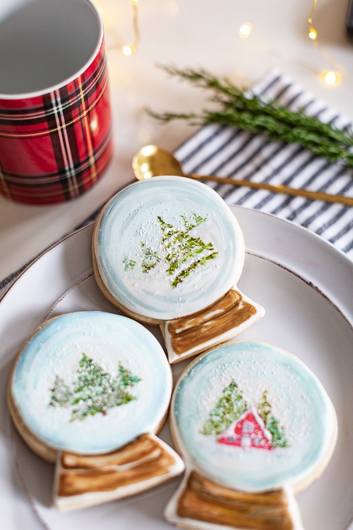 three decorated cookies sitting on top of a white plate