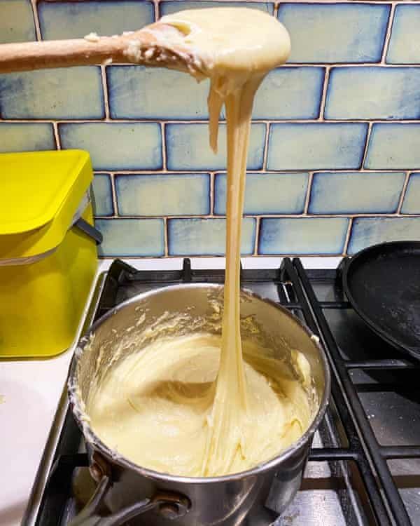 a person pouring batter into a pot on the stove