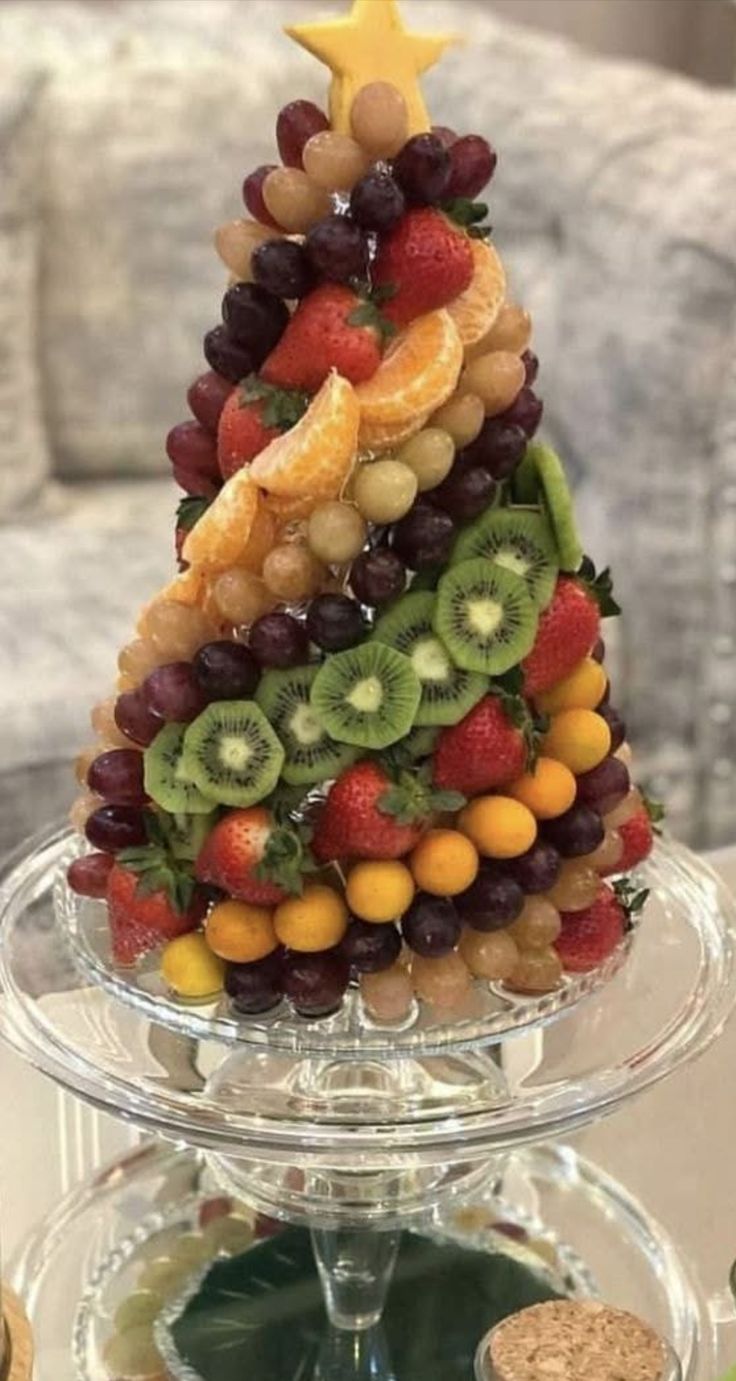 a christmas tree made out of fruit on a glass platter with wine corks