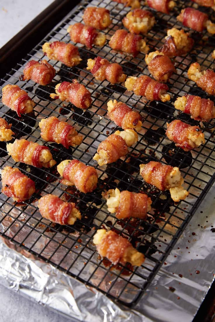 bacon wrapped chicken bites sitting on top of a grill