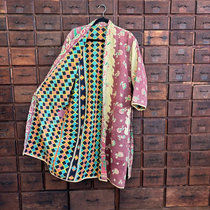 Hand stitched in India by a family of textile artisans. Each robe is a unique item, and no two are alike. One size really does fit all. 44" L Sleeve length 17 1/2" L Shoulder 19 1/2" W About Kantha Traditionally, Kantha was about upcycling old clothes and giving them a new life, but the craft also acted as a canvas for women to express their artistic talents, and was typically practised by every woman in a village for her household. Multicolor Cotton Kimono With Batik Print, Traditional Cotton Outerwear With Natural Dye, Multicolor Kimono With Block Print, Multicolor Cotton Robe For Festival, Traditional Cotton Robe With Kimono Sleeves, Multicolor Long Cotton Robe, Long Multicolor Cotton Robe, Traditional Long Sleeve Block Print Kimono, Traditional Long Sleeve Batik Print Kimono