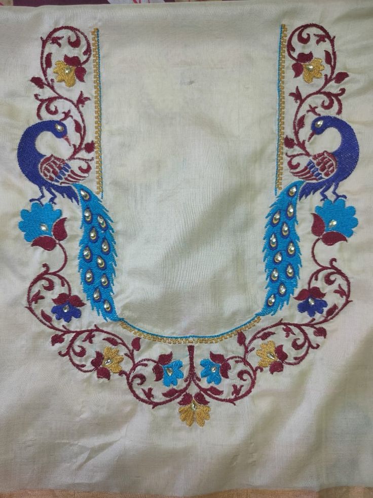 an embroidered cloth with peacocks and flowers on it