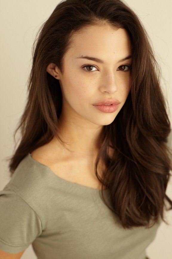 a woman with long brown hair posing for the camera