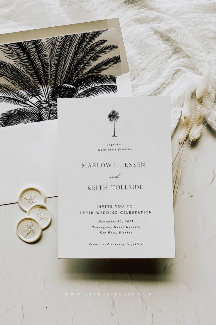 the wedding stationery is laid out on top of an envelope, with two rings