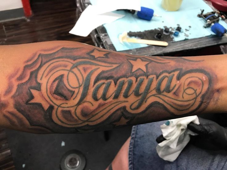 a man with a tattoo on his arm that says tampa in cursive writing