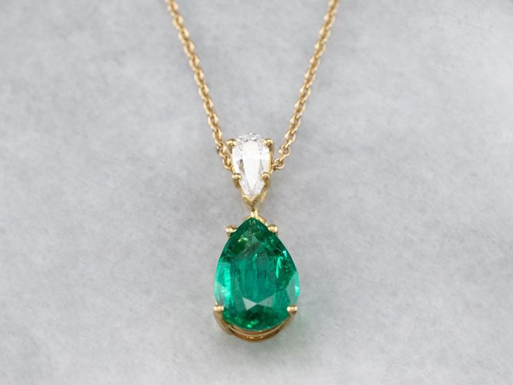 This lovely necklace was crafted in our shop, using both vintage and modern pieces. The center gem is a deep, gorgeous green emerald from our collection! We've used a brilliant diamond as an accent, and set them both in a simple yellow gold pendant with clean, simple lines. Set perfectly on a yellow gold rolo 16-inch chain, making this stunning piece ready to wear or gift! Metal: 18K Yellow Gold Gem: Emerald 2.57 Carats Gem Measurements: 12.0 x 8.2 mm, Pear Cut Accents: Diamond .42 Carats, F in Emerald And Diamond Necklace, Chain Making, Emerald Necklace, Lovely Necklace, Emerald Jewelry, Yellow Gold Pendants, Green Emerald, Brilliant Diamond, Simple Lines