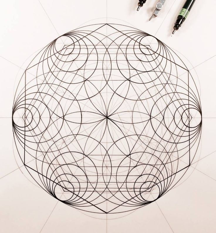 a pen and some pens sitting on top of a paper with an intricate design in the middle