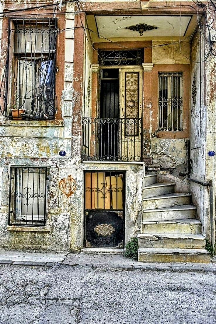 an old run down building with stairs leading up to the second floor and another door