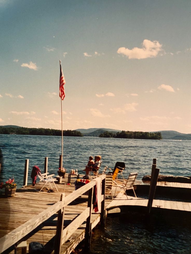 a dock with chairs and an american flag on it