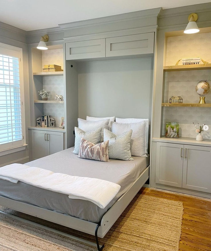 a bed sitting in the middle of a bedroom next to a book shelf filled with books