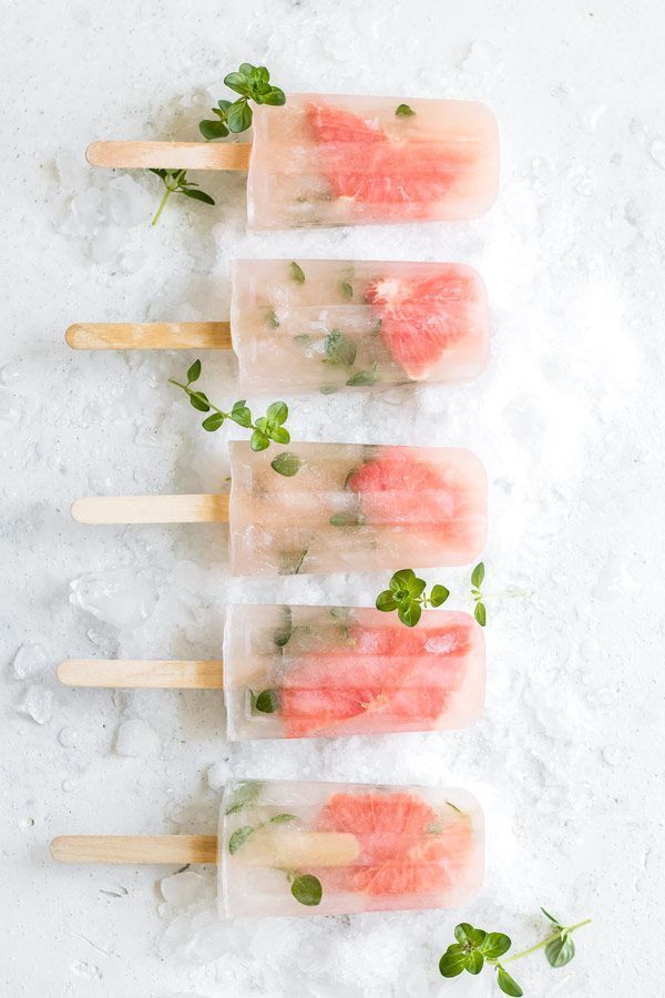 four popsicles filled with watermelon and mint on top of snow covered ground