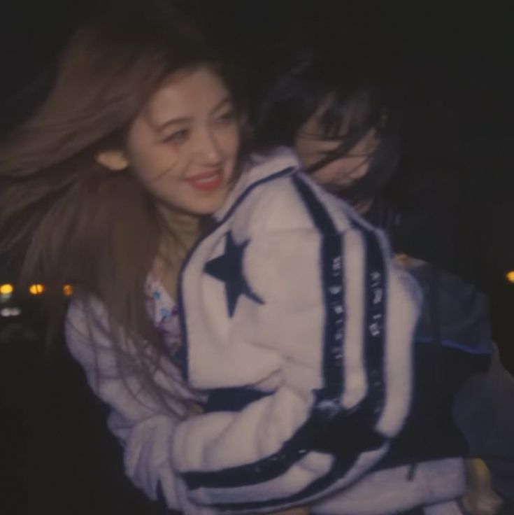 two girls hugging each other in the dark