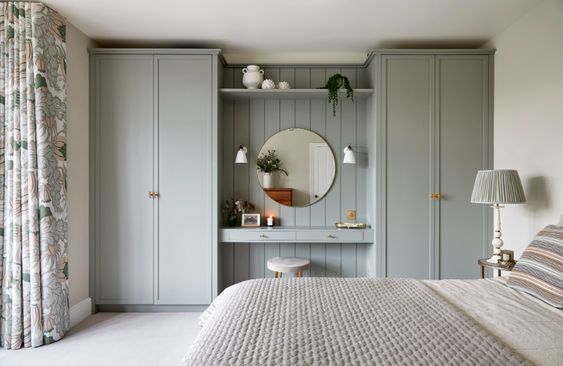 a bedroom with a bed, dresser and mirror on the wall next to a window