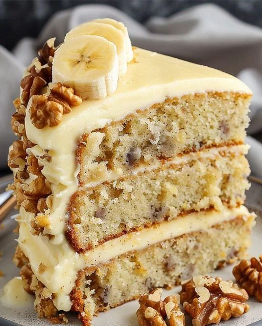 a slice of banana cake on a plate with walnuts