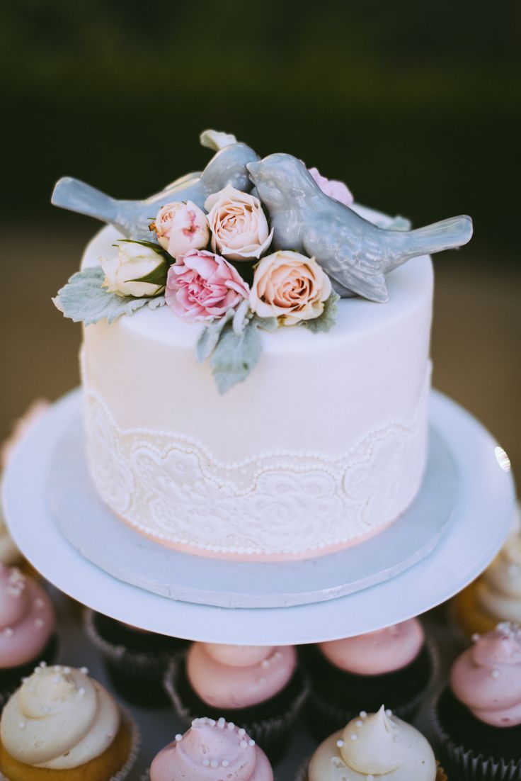 a wedding cake and cupcakes on a table