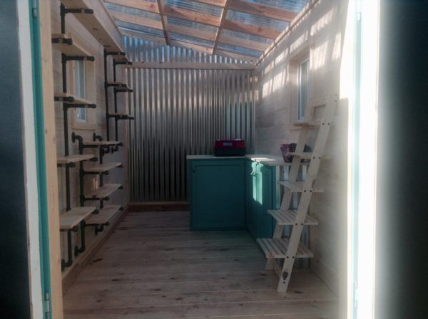 the inside of a storage room with shelves and ladders