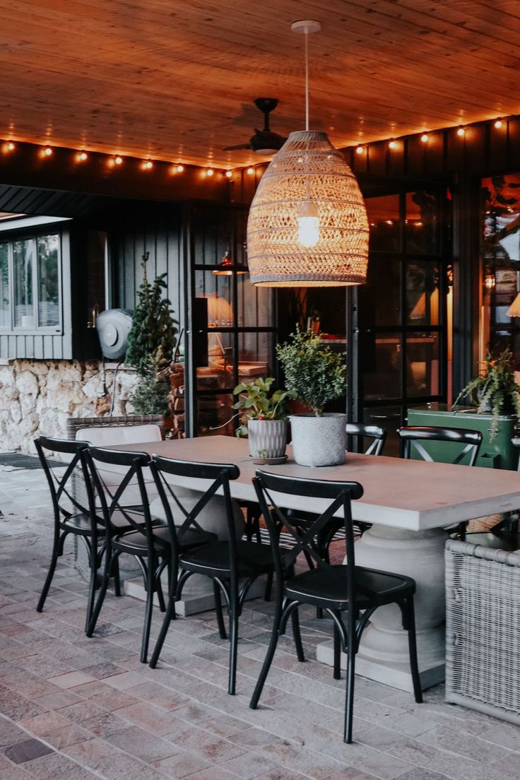 an outdoor dining area with patio furniture and string lights