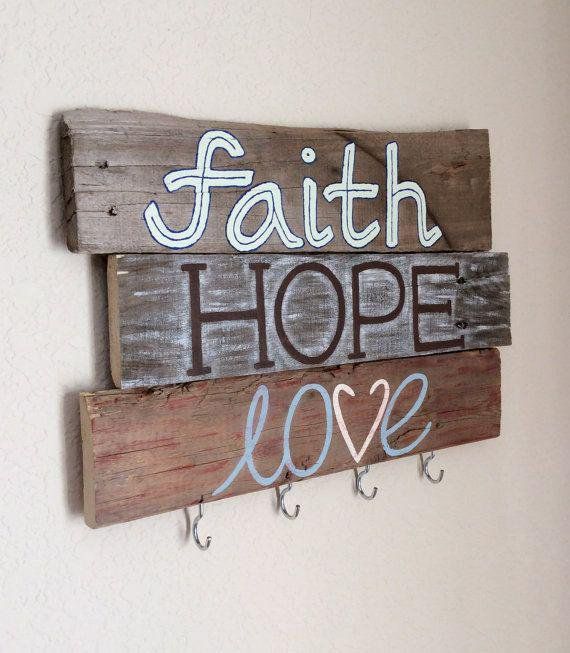 a wooden sign that says faith, hope, love and fishing hooks hang on the wall