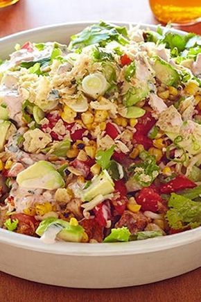 a white bowl filled with salad on top of a wooden table