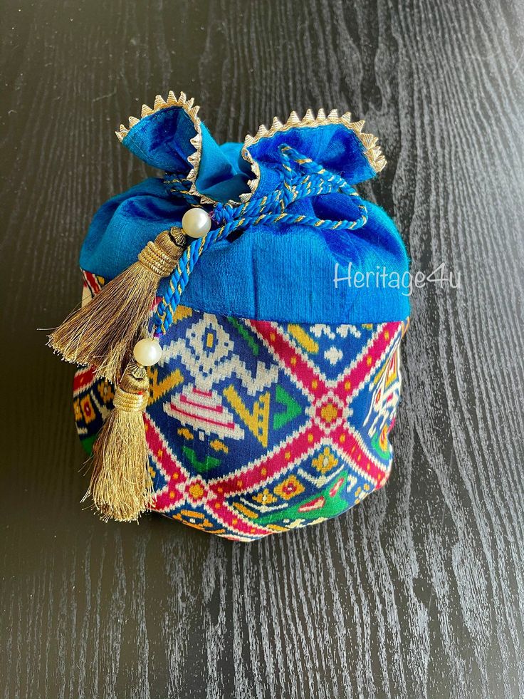 Beautiful Patola Potli bags Ditch your designer clutches for your next wedding or prewedding event and rock these festive potli bags Material: silk Handmade tassels Gold lace around the face of the potli Perfect for any occasion such as weddings, pre wedding ceremonies, bridal showers , and baby showers. Wear to any event all in all! follow us on insta and facebook for more photos @ Heritage_4u Festive Celebration Bags With Tassels, Festival Potli Bag With Tassels For Party, Elegant Festive Tassel Bags, Elegant Festive Bags With Tassels, Festive Party Bags With Tassels, Festive Elegant Potli Bag With Tassels, Wedding Potli Bag With Tassels, Festival Party Bags With Tassels, Party Bags With Tassels For Festivals