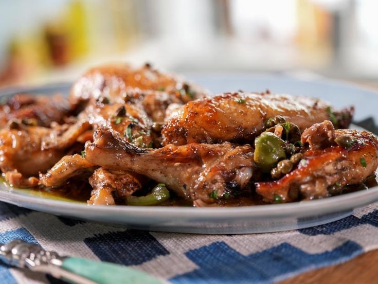 a close up of a plate of food with meat and vegetables on it next to a fork