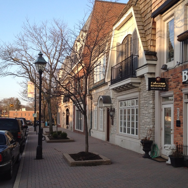 cars parked on the side of a street next to tall brick buildings with balconies