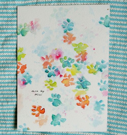 a card with colorful flowers on it sitting on top of a blue and white striped cloth