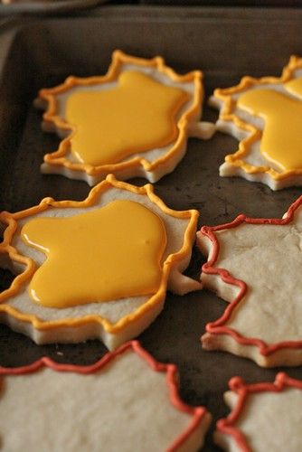 some cookies with yellow icing are on a pan