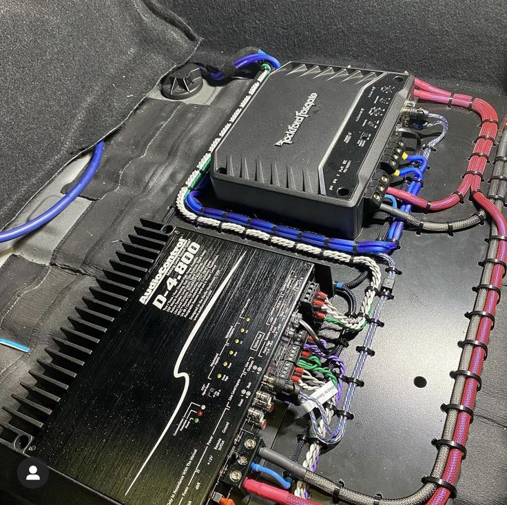 the inside of a car with wires and electronic equipment in it's back compartment