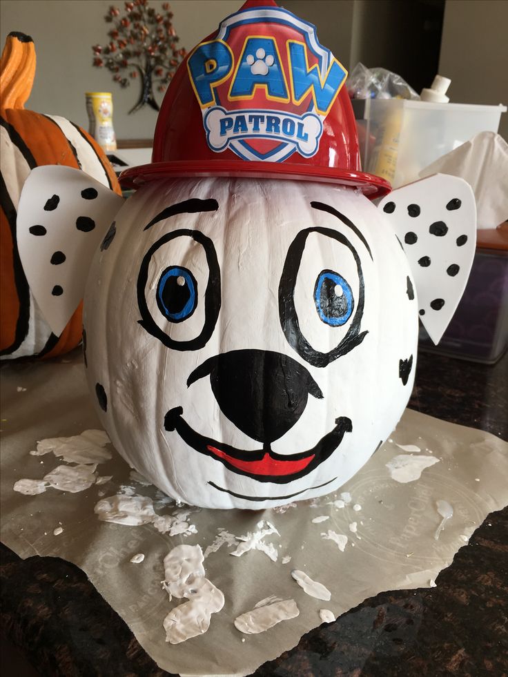 a white pumpkin with a fireman's hat on it sitting on top of a table