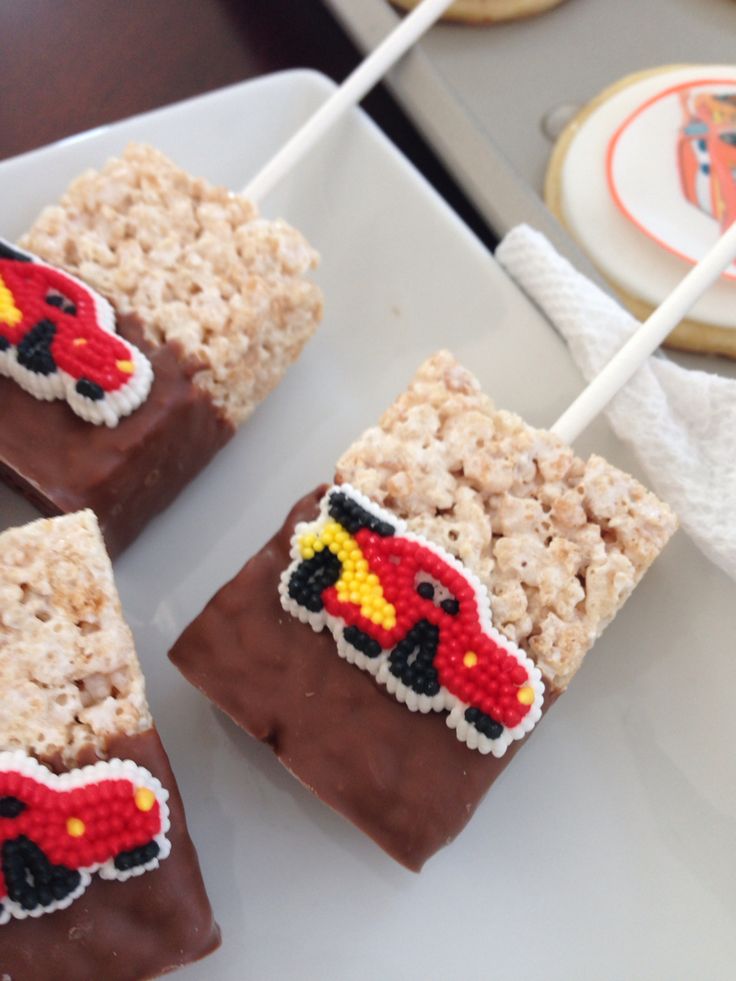 some rice krispy treats are on a plate with toothpicks in the shape of cars