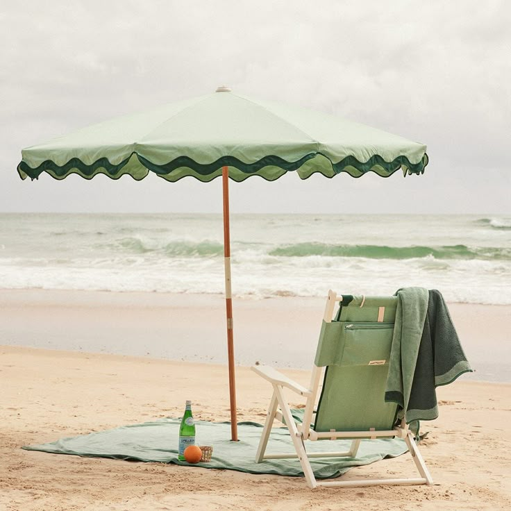 an umbrella and chair sitting on the beach