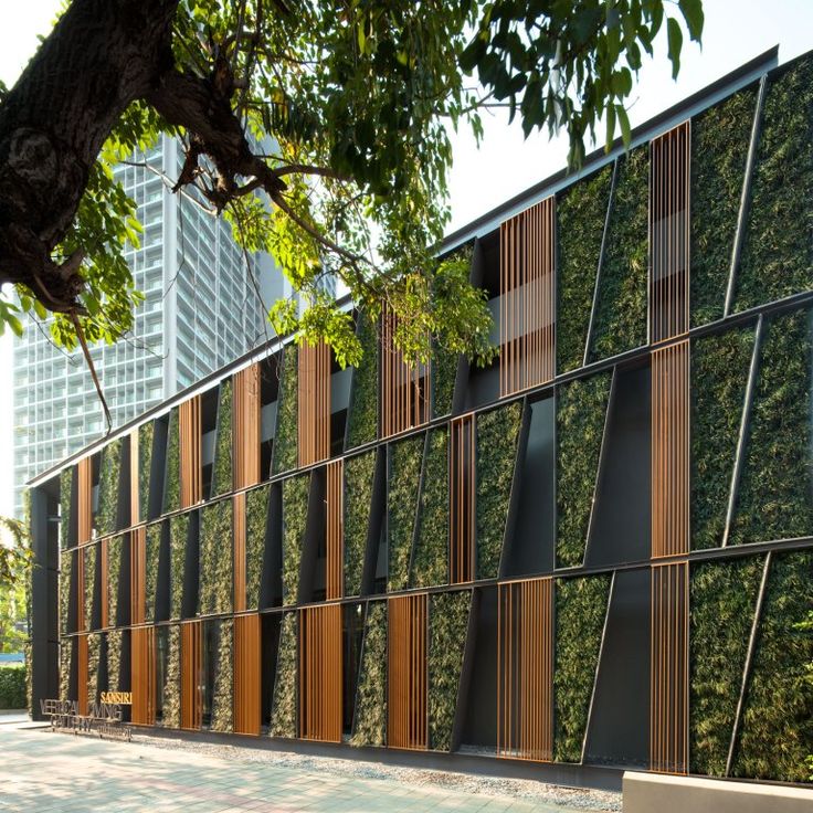 an office building with vertical plants on the side and wooden slats at the front