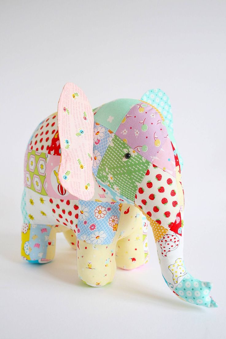 an elephant made out of fabric sitting on top of a white surface with polka dots