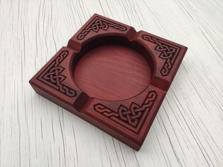 a wooden box with an intricate design on the front and sides, sitting on a white surface