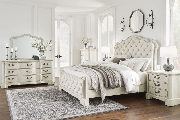 a bedroom with white furniture and wooden floors