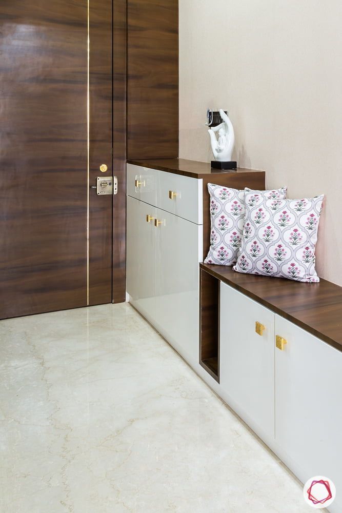 an empty room with white cabinets and wood accents on the wall, along with a decorative throw pillow