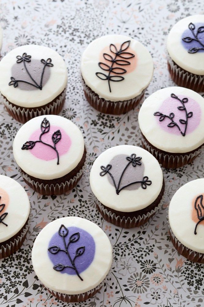 cupcakes decorated with flowers and leaves on a doily